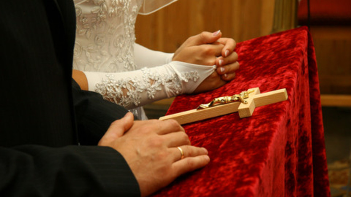 Couple Kneeling With Crucifix